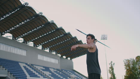 Slow-motion:-a-Male-athlete-at-the-stadium-concentrates-runs-up-and-throws-a-javelin.-Preparation-for-the-Olympic-games-all-around